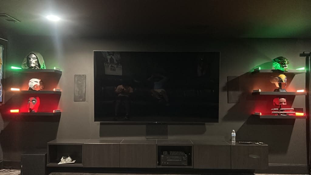 Home theater media wall with a large mounted TV, AV receiver, subwoofer and LED-lit floating display shelves, Nashville TN
