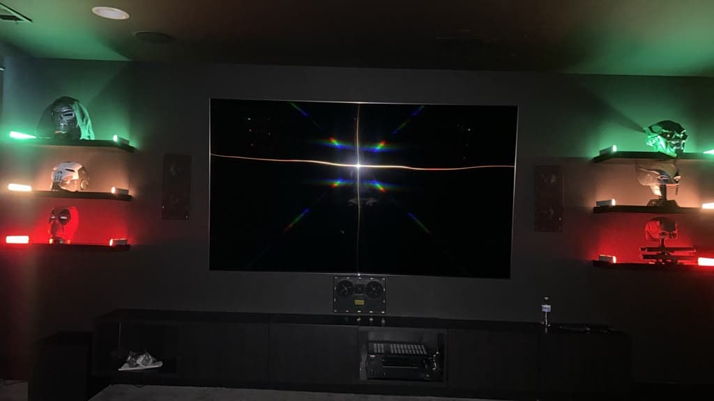 Home theater TV with on-wall surround speakers and LED-lit collectible shelves either side, Nashville TN
