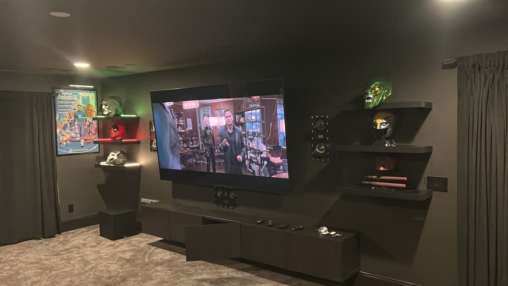 Home theater TV wall with surround speakers either side and floating display shelves, Nashville TN